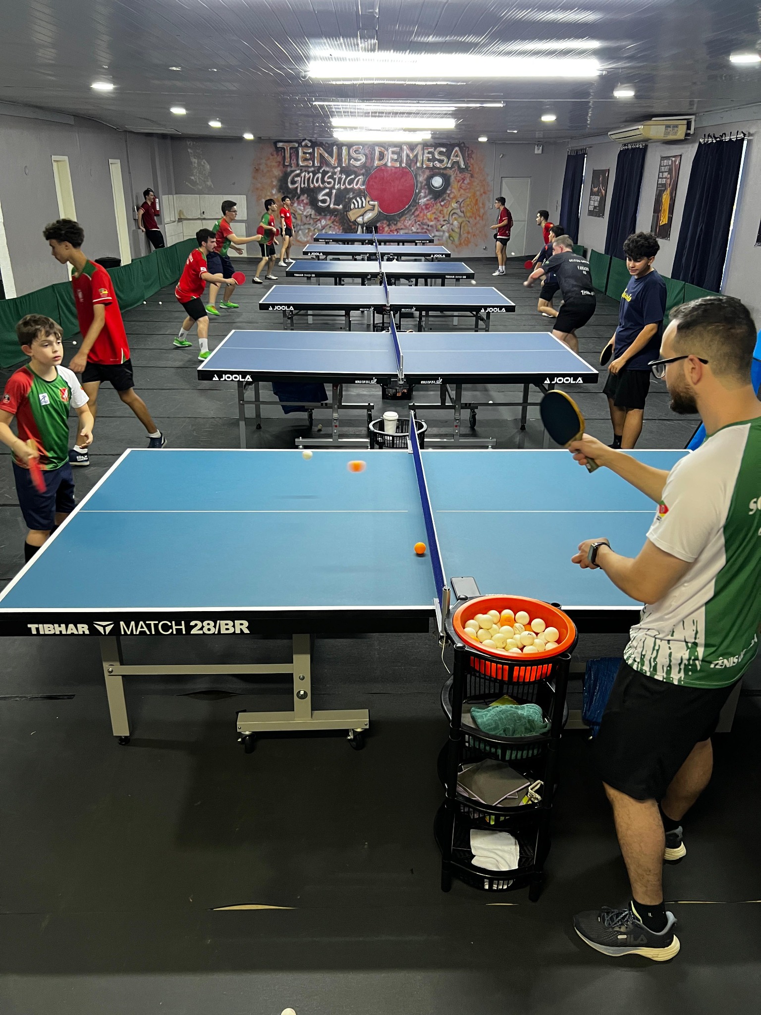 Jogadores praticando em várias mesas na sala da Ginástica